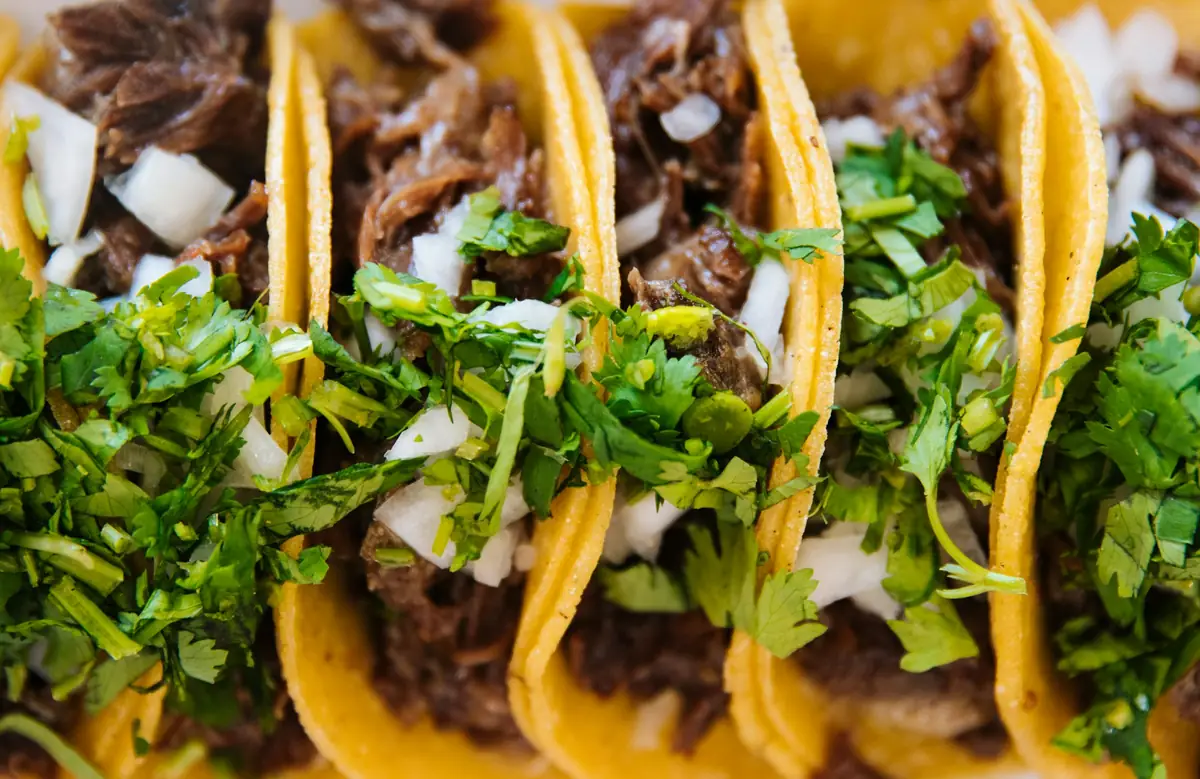 Close-up of street tacos topped with chopped onion and coriander