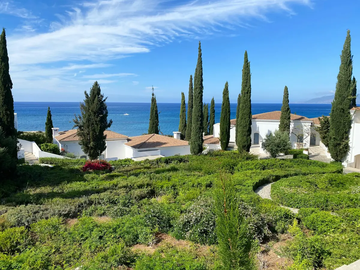 Mediterranean villa garden with cypress trees overlooking the sea